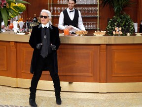 FILE - In this March 10, 2015 file photo, German fashion designer Karl Lagerfeld receives applause after Chanel's ready-to-wear fall-winter 2015-2016 fashion collection presented in Paris. French authorities are investigating designer Karl Lagerfeld’s taxes, while a French magazine says he used off-shore tax havens to avoid paying millions of euros to the French government. (AP Photo/Francois Mori, File)