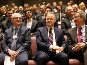 Bank of Canada Governor Stephen Poloz, centre, sits with Ottawa Mayor Jim Watson before delivering a speech in Ottawa on Thursday.