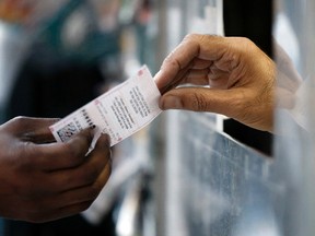 A person purchases Powerball lottery tickets from a newsstand in Philadelphia on Jan. 6, 2016. (AP Photo/Matt Rourke)