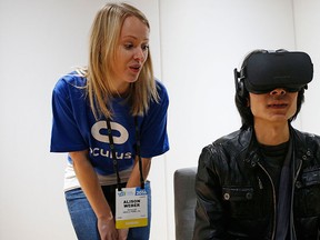 Alison Weber, left, instructs Peijun Guo on using the Oculus Rift VR headset at the Oculus booth at CES International, Wednesday, Jan. 6, 2016, in Las Vegas. (AP Photo/John Locher)