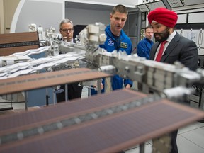 Minister of Innovation, Science and Economic Development Navdeep Bains looks over a model of the International Space Station with Canadian astronaut Jeremy Hansen at the Canadian Space Agency, in St-Hubert, Que., on Thursday, Jan. 7, 2016. THE CANADIAN PRESS/Paul Chiasson