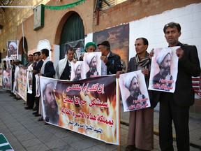 Shiite rebels, known as Houthis, hold posters of late Shiite cleric Nimr al-Nimr, who was executed in Saudi Arabia, during an anti-Saudi protest outside the Saudi embassy in Sanaa, Yemen, Thursday, Jan. 7, 2016. (AP Photo/Hani Mohammed)