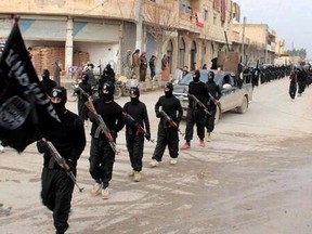 This undated file image posted on a militant website on Jan. 14, 2014, which has been verified and is consistent with other AP reporting, shows fighters from the Islamic State of Iraq and the Levant (ISIL) marching in Raqqa, Syria. (THE CANADIAN PRESS/AP/Militant Website, File)