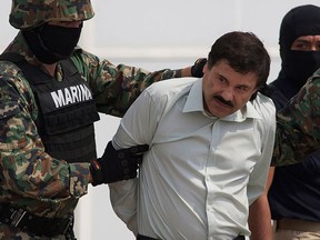 In this Feb. 22, 2014 file photo, Joaquin "El Chapo" Guzman is escorted to a helicopter in handcuffs by Mexican navy marines at a navy hanger in Mexico City, Mexico. (AP Photo/Eduardo Verdugo, File)