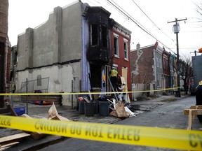 City workers board up the scene of a fatal fire Friday, Jan. 8, 2016, in Philadelphia. (AP Photo/Matt Rourke)
