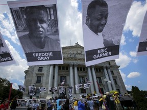 Pictures of Eric Garner, Freddie Gray and Nizah Morris are seen while people take part in the Million People's March Against Police Brutality, Racial Injustice and Economic Inequality in Newark, New Jersey in this July 25, 2015, file photo. Baltimore officials have reached a tentative $6.4 million wrongful death settlement with the family of Freddie Gray, an unarmed black man who died in April from an injury sustained in police custody, the Washington Post reported on Tuesday, citing two unnamed sources.REUTERS/Eduardo Munoz/Files