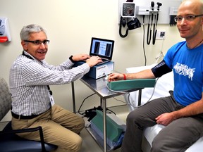 Dr. Neville Suskin, medical director of St. Joseph’s Cardiac Rehabilitation and Secondary Prevention Program (left), and Tim Hartley, research co-ordinator at St. Joseph’s Health Care London, demonstrate the AngioDefender in London Ont. January 7, 2016.  CHRIS MONTANINI\LONDONER\POSTMEDIA NETWORK