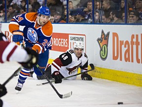 Edmonton's Brad Hunt (24) chases the puck as Arizona's Jordan Martinook (48) hits the ice during the third period of the Edmonton Oilers' NHL hockey game against the Arizona Coyotes at Rexall Place in Edmonton, Alta., on Saturday, Jan. 2, 2016. The Oilers won 4-3. Codie McLachlan/Edmonton Sun/Postmedia Network