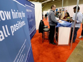 Exhibitors speak with visitors at the 2014 Spring National Job Fair and Training Expo in Toronto, in this April 3, 2014, file photo. Canada added more jobs than expected in December 2015, partly making up for heavy losses the previous month, while the unemployment rate held at 7.1%, welcome news for an economy hit by low oil prices. (REUTERS/Aaron Harris/Files)