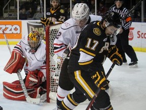 Sarnia Sting forward Travis Konecny searches for the puck in his feet with Owen Sound Attack defenceman Jacob Friend defending him and goalie Michael McNiven keeping an eye on the play during the Ontario Hockey League game at the Sarnia Sports and Entertainment Centre on Jan. 8, 2016 in Sarnia, Ont. Konecny, playing in his first game with the Sting, scored a hat trick. (Terry Bridge, Sarnia Observer)