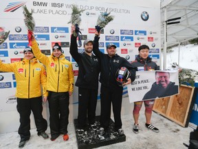 Carlo Valdes and Steven Holcomb (center) of the United States, celebrate their win in the two-man bobsled World Cup race in Lake Placid, N.Y., on Friday, Jan. 8, 2016. At left, Germany's Nico Walther and Christian Poser, second place, and at right, South Korea's Yunjong Won, third place, join the celebration. Won holds a photo of coach Malcolm (Gomer) Lloyd who recently died. (Mike Groll/AP Photo)
