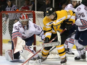 Kingston Frontenacs' Spencer Watson tries to control the puck in front of Oshawa Generals  goalie Jeremy Broudeur as defenceman Daniel Roberston comes in to help during Ontario Hockey League action the at the Rogers K-Rock Centre in Kingston on Friday night. (Ian MacAlpine/The Whig-Standard)