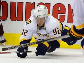 Ryan Johansen lunges for a loose puck in his first game with the Predators on Friday night. He scored on his second shift with his new team. (Associated Press)