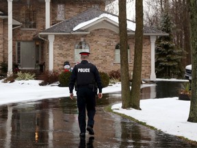 Const. Paul Fyke walks toward a home on O'Neill Drive Saturday morning. City police are investigating a "serious incident" which sent one person to hospital, but officers are saying little about the case.