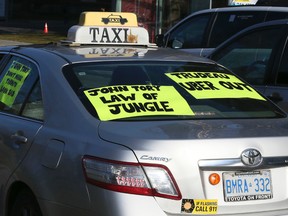 Taxi drivers protest Uber by driving around Queen's Park honking their horns on Dec. 9. (Veronica Henri/Toronto Sun/Postmedia Network)