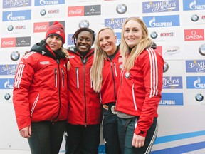 The Canadian four-person bobsled team of Genevieve Thibault, Cynthia Appiah, driver Kaillie Humphries and Melissa Lotholz pose after the World Cup race on Saturday, Jan. 9, 2016, in Lake Placid, N.Y. They became the first all female team to compete against men in a World Cup race. (AP Photo/Mike Groll)