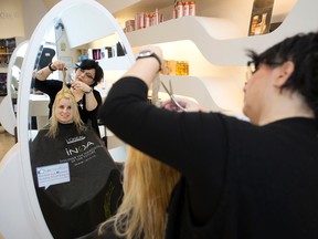 Anna Spaziani styles Cindy Thomas' hair during Fresh & Co Salons' cut-a-thon fundraiser for Syrian refugees, in Edmonton Alta. on Sunday Jan. 10, 2016. David Bloom/Edmonton Sun/Postmedia Network
