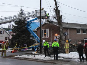 Kingston Fire and Rescue technical rescue team works with Frontenac Paramedics to do a mid-air assessment and rescue of a man hit by a large branch that also disabled the cherry picker he had been using on Weller Avenue around 4 p.m. on Saturday. (Julia McKay/The Whig-Standard)