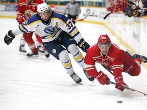 Laurentian Voyageurs Caleb Apperson trips up Jake Bullen of RMC during OUAA hockey action in Sudbury, Ont. on Sunday January 10, 2016. RMC  defeated Laurentian in a shootout.Gino Donato/Sudbury Star/Postmedia Network