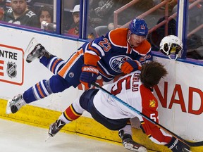 Matt Hendricks takes out Florida's Aaron Eckblad during Sunday's chippy NHL game (Ian Kucerak, Edmonton Sun).