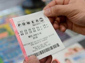 A person holds a Powerball ticket in New York January 10, 2016. REUTERS/Stephanie Keith