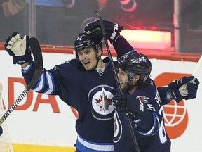 Centre Mark Scheifele (left) celebrates a goal with winger Mathieu Perreault earlier this season. Scheifele is out with an injury for another week, but Perreault is probable for Tuesday's game against San Jose. (Brian Donogh/Winnipeg Sun file photo)