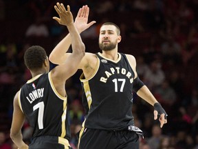 Toronto Raptors center Jonas Valanciunas (17) high fives guard Kyle Lowry (7) after a score against the Philadelphia 76ers during the second half at Wells Fargo Center. The Raptors won 108-95. Bill Streicher-USA TODAY Sports
