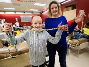Pediatric oncology patient Aidan Sheets, 10, and her mother Shelley Sheets pose for a photo with Aidan's bravery beads at the Canadian Blood Services blood donor clinic, 8249 - 114 St., in Edmonton Alta. on Monday Jan. 11, 2016.  David Bloom/Edmonton Sun