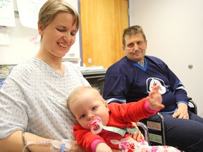 Fire victims Alena Giertmane (left) and her husband Dzintars Giertmanis hold their daughter Agnese during an interview on Monday. The couple were injured during an apartment fire on New Year's Day. (Brian Donogh/Winnipeg Sun)