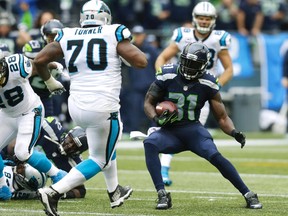 Seattle Seahawks strong safety Kam Chancellor runs toward Carolina Panthers guard Trai Turner after Chancellor intercepted a pass in the second half of a game in Seattle on Oct. 18, 2015. (AP Photo/Stephen Brashear)