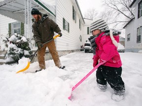 Brooklyn and Randy Hilton shovel outside their Belleville home Tuesday morning.