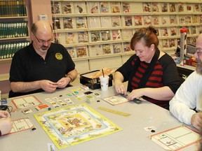 Jeffrey Beeler (left) teaches some new gamers the tricks of the trade regarding the board game Talisman. Beeler helped organize a weekly board game night, which takes place every Thursday evening at Sarnia's Public Library. 
CARL HNATYSHYN/SARNIA THIS WEEK