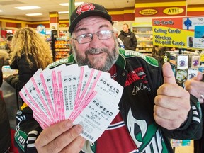 Robert Charbonneau, from St-Donat, Que., holds up $1,000 worth of Powerball tickets for himself and his friends at a convenience store, Tuesday, January 12, 2016 in the border town of Champlain, N.Y. The jackpot has reached a record setting $1.5 billion. THE CANADIAN PRESS/Ryan Remiorz