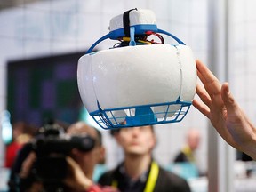 A person pushes the Fleye drone as it flies at the Fleye booth during CES International, Thursday, Jan. 7, 2016, in Las Vegas. The single propeller of the drone is enclosed for safety. (AP Photo/John Locher)