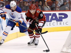 Oilers forward Lauri Korpikoski battles Coyotes forward Max Domi for the puck during first period action Tuesday in Glendale, Ariz. (AP photo)