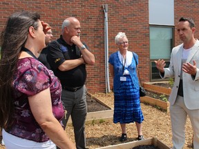 Frank Ferragine gives gardening advice at Bradford District High School's Food For Thought Garden in Bradford, Ont. on June 10, 2015. (Miriam King/Bradford Times/Postmedia Network)