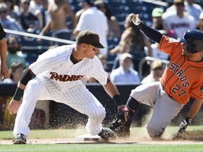 Jose Altuve #27 of the Houston Astros slides into third base ahead of the tag of Will Middlebrooks #11 of the San Diego Padres during the ninth inning of a baseball game at Petco Park April 29, 2015 in San Diego, California.   Denis Poroy/Getty Images/AFP