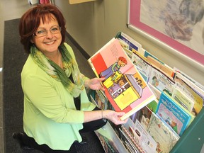Janice Webb, the co-ordinator of the Better Beginnings program in Kingston, holds one of the books they offer to children at their office. The program promotes literacy among the children. (Michael Lea/The Whig-Standard)