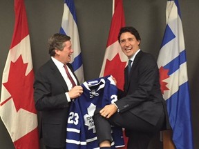 Prime Minister Justin Trudeau shows off his Montreal Canadiens socks as Toronto Mayor John Tory presents him with a Maple Leafs jersey Wednesday, Jan. 13, 2016 at City Hall. (Twitter photo)