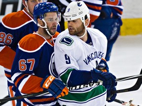 Oilers forward Benoit Pouliot and Zack Kassian, then with the Vancouver Canucks, exchange words during a game at Rexall Place last season. (Codie McLachlan, Edmonton Sun)