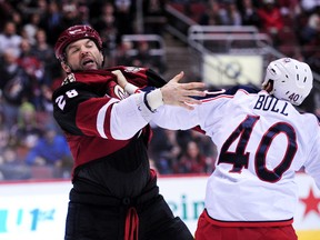 Arizona Coyotes left winger John Scott (left) and Columbus Blue Jackets right winger Jared Boll fight during the second period at Gila River Arena. (Matt Kartozian-USA TODAY Sports)