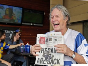 Rams fan Don Kirst holds a copy of the Los Angeles Daily News celebrating the impending return of the NFL football team to the Los Angeles area, at Big Wangs sports bar in LA on Jan. 13, 2016. (AP Photo/Nick Ut)