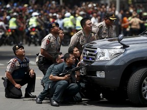 Police officers react near the site of a blast in Jakarta, Indonesia, January 14, 2016. Several explosions went off and gunfire broke out in the centre of the Indonesian capital on Thursday and police said they suspected a suicide bomber was responsible for at least one the blasts. REUTERS/Darren Whiteside