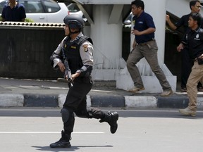 An Indonesian policeman runs near the site of a blast in Jakarta, Indonesia, January 14, 2016.   Several explosions went off and gunfire broke out in the center of the Indonesian capital on Thursday and police said they suspected a suicide bomber was responsible for at least one the blasts. REUTERS/Beawiharta
