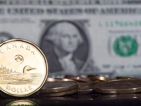 The Canadian dollar coin, the Loonie, is displayed next to the US dollar, January 30, 2015 in Montreal. THE CANADIAN PRESS/Paul Chiasson