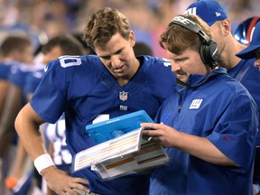 In this Aug. 22, 2015, file photo, New York Giants offensive coordinator Ben McAdoo confers with quarterbacks Eli Manning, left, and Ryan Nassib, right, during the first half of a preseason game in East Rutherford, N.J. (AP Photo/Bill Kostroun, File)