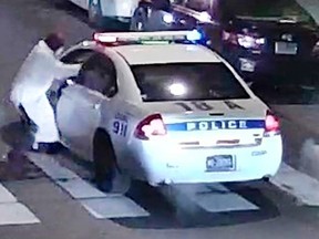 A still image from surveillance video shows a gunman (L) approaching a Philadelphia Police vehicle in which Officer Jesse Hartnett was shot shortly before midnight in Philadelphia, Pennsylvania this Philadelphia Police Department image released on January 8, 2016. A gunman claiming to have pledged allegiance to Islamic State militants shot and seriously wounded a Philadelphia police officer in an ambush on his patrol car, the city's police commissioner said on Friday.  REUTERS/Philadelphia Police Department/Handout