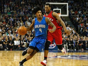 Orlando Magic's Elfrid Payton drives forward as Toronto Raptors guard Kyle Lowry defends during the first half of an NBA basketball game at the O2 arena in London on Jan. 14, 2016. (AP Photo/Alastair Grant)