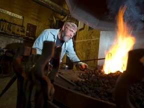Blacksmith Scott McKay heats a piece of steel in a furnace in his workshop. (CRAIG GLOVER, The London Free Press)