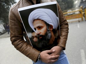 A Shi'ite Muslim man holds a picture of cleric Sheikh Nimr al-Nimr during a protest against the execution of Nimr, who was executed along with others in Saudi Arabia in this January 4, 2016 file photo. In the wake of these execution, Algonquin College in Ottawa is facing calls to pull out of the country where it runs a men's only campus. REUTERS/Adnan Abidi/Files